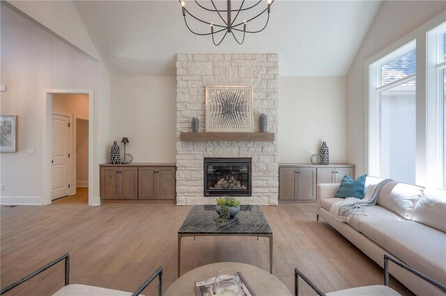 6753 Longview St, Shawnee, KS 66218 - living area featuring lofted ceiling, a chandelier, light wood-type flooring, and a stone fireplace