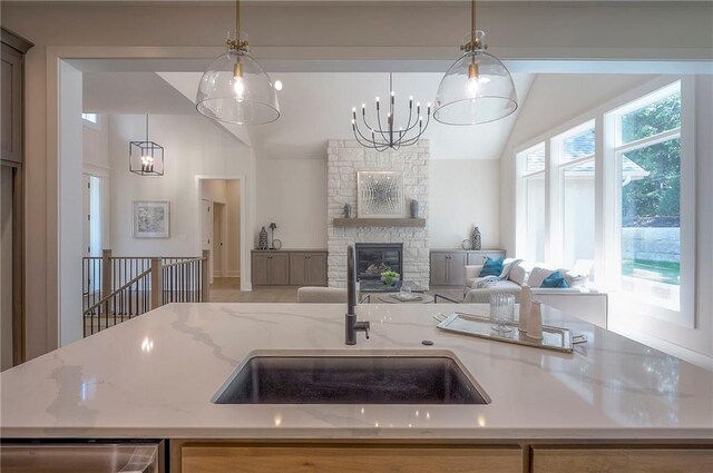 6753 Longview St, Shawnee, KS 66218 - kitchen featuring vaulted ceiling, open floor plan, light stone countertops, hanging light fixtures, and a chandelier