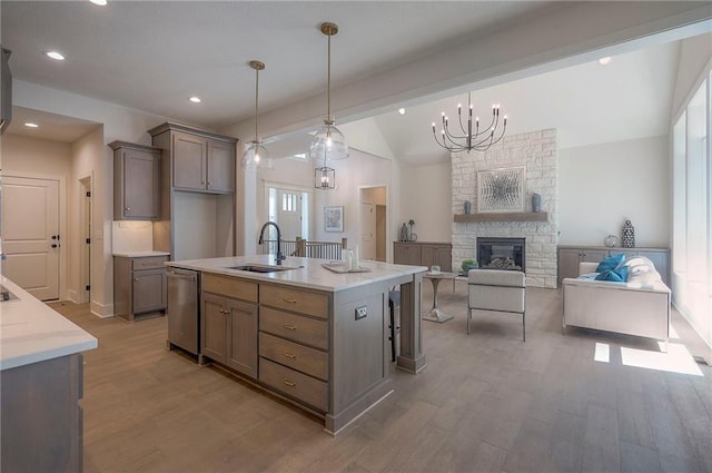 6753 Longview St, Shawnee, KS 66218 - kitchen featuring lofted ceiling, light wood-style flooring, dishwasher, a fireplace, and decorative light fixtures