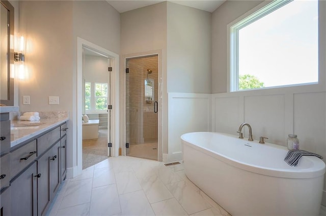 6753 Longview St, Shawnee, KS 66218 - full bathroom with vanity, a shower stall, a soaking tub, a decorative wall, and marble finish floors