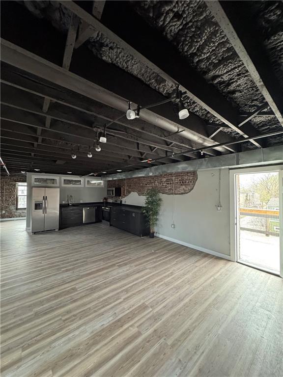 1018 Missouri Ave, Kansas City, MO 64106 - unfurnished living room featuring light wood-style floors and bar area