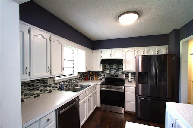 109 SE Rockwood St, Blue Springs, MO 64014 - kitchen with stainless steel appliances, white cabinets, dark wood-style flooring, decorative backsplash, and light countertops