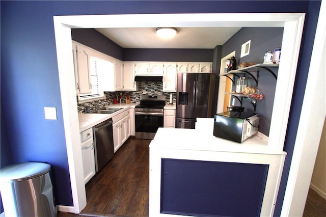 109 SE Rockwood St, Blue Springs, MO 64014 - kitchen with appliances with stainless steel finishes, under cabinet range hood, white cabinetry, and dark wood-type flooring