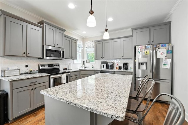 1016 SE Forest Ridge Ct, Blue Springs, MO 64014 - kitchen featuring stainless steel appliances, gray cabinetry, crown molding, light stone counters, and recessed lighting