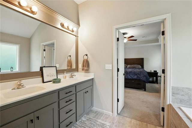 1016 SE Forest Ridge Ct, Blue Springs, MO 64014 - bathroom featuring double vanity, ceiling fan, tiled tub, ensuite bath, and wood finished floors