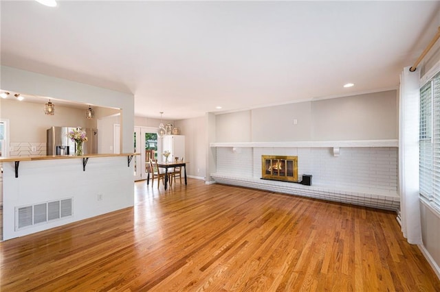 1806 E 125th St, Kansas City, MO 64146 - living room featuring a fireplace, light wood-style floors, a chandelier, and recessed lighting