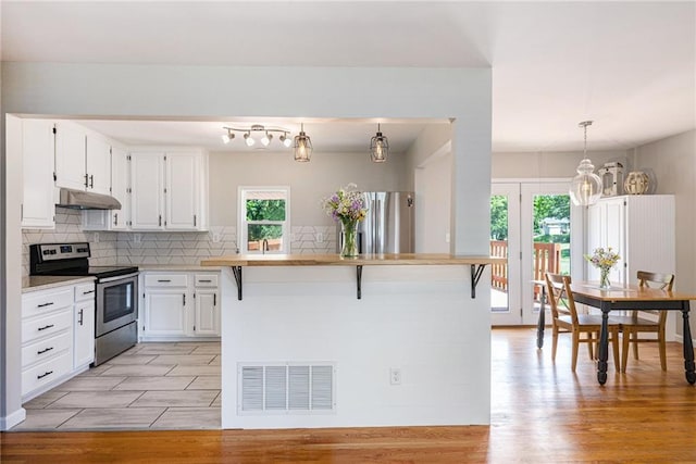 1806 E 125th St, Kansas City, MO 64146 - kitchen with stainless steel appliances, under cabinet range hood, healthy amount of natural light, and white cabinets