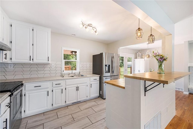 1806 E 125th St, Kansas City, MO 64146 - kitchen featuring stainless steel appliances, wooden counters, and white cabinets