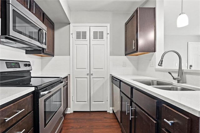 435 W 9th St Unit 204, Kansas City, MO 64105 - kitchen featuring appliances with stainless steel finishes, dark wood-style flooring, dark brown cabinets, backsplash, and pendant lighting