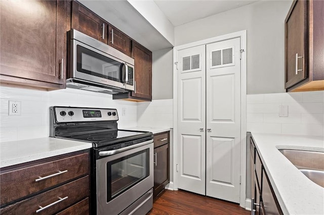 435 W 9th St Unit 204, Kansas City, MO 64105 - kitchen featuring stainless steel appliances, backsplash, dark brown cabinetry, and light countertops