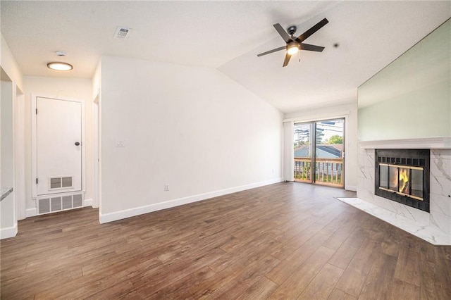 8143 Holmes Rd Unit 202, Kansas City, MO 64131 - unfurnished living room with wood finished floors, a tile fireplace, ceiling fan, and vaulted ceiling