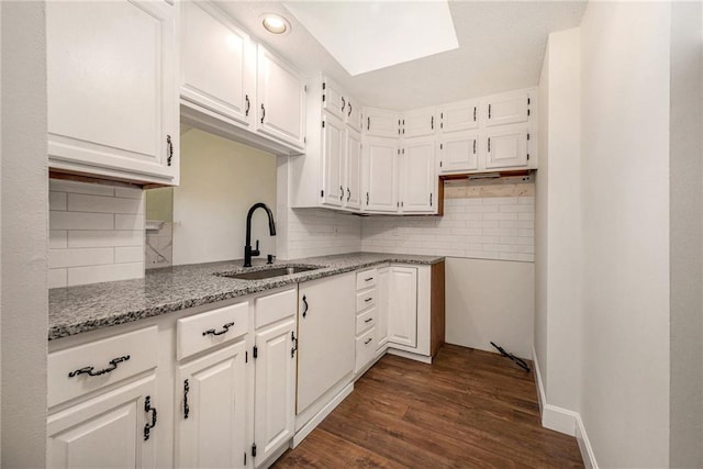 8143 Holmes Rd Unit 202, Kansas City, MO 64131 - kitchen featuring tasteful backsplash, white cabinetry, and light stone counters
