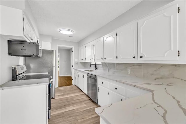 2647 Minnesota Ave, Kansas City, KS 66102 - kitchen featuring stainless steel appliances, light wood finished floors, white cabinets, and backsplash