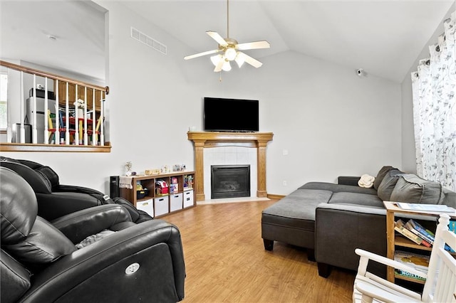 1005 Granada Dr, Raymore, MO 64083 - living room featuring a ceiling fan, lofted ceiling, light wood finished floors, and a tile fireplace