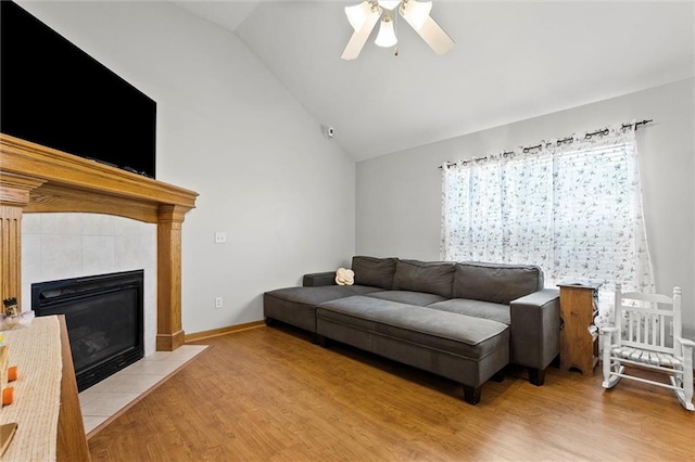 1005 Granada Dr, Raymore, MO 64083 - living area featuring wood finished floors, a ceiling fan, a fireplace, and high vaulted ceiling