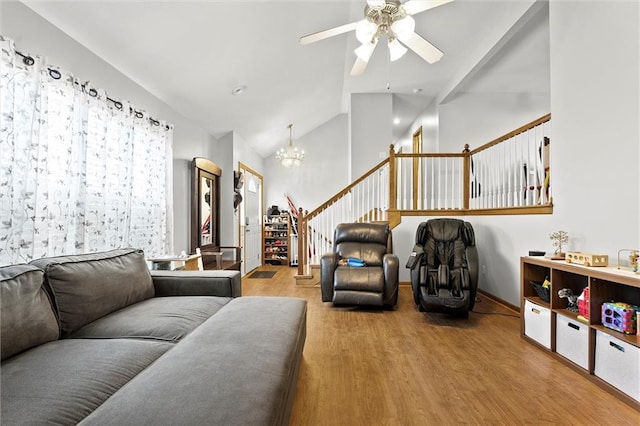 1005 Granada Dr, Raymore, MO 64083 - living area with wood finished floors, a chandelier, stairway, a ceiling fan, and high vaulted ceiling