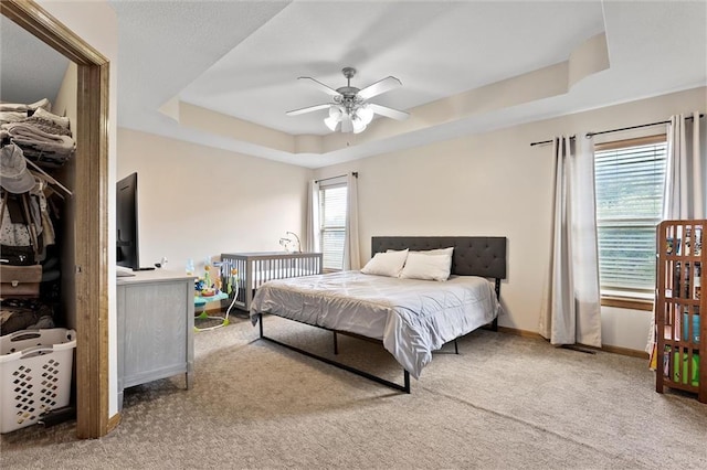 1005 Granada Dr, Raymore, MO 64083 - bedroom with a raised ceiling, light carpet, and a ceiling fan