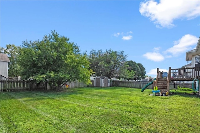 1005 Granada Dr, Raymore, MO 64083 - fenced backyard featuring a shed, a playground, and a deck