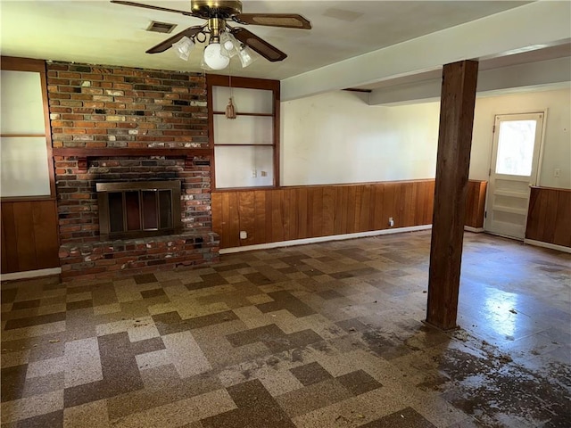 8812 W 72nd St, Overland Park, KS 66204 - unfurnished living room with wainscoting, ceiling fan, wood walls, tile patterned floors, and a fireplace