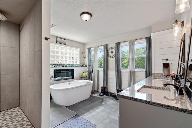 4815 Cheyenne Ln, Mclouth, KS 66054 - bathroom featuring double vanity, a soaking tub, a glass covered fireplace, tiled shower, and a textured ceiling