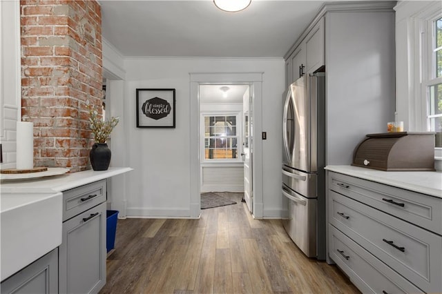 6000 Cherry St, Kansas City, MO 64110 - kitchen featuring freestanding refrigerator, gray cabinetry, wood finished floors, and ornamental molding