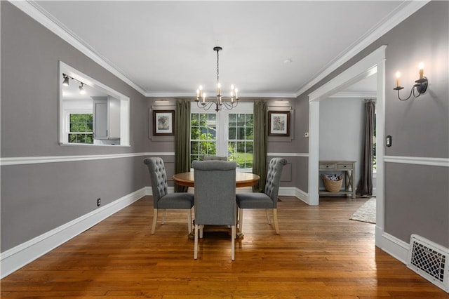 6000 Cherry St, Kansas City, MO 64110 - dining room featuring healthy amount of natural light, a chandelier, crown molding, and hardwood / wood-style flooring