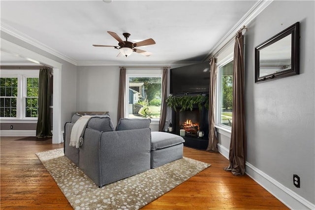 6000 Cherry St, Kansas City, MO 64110 - living room with a warm lit fireplace, crown molding, hardwood / wood-style flooring, and a ceiling fan