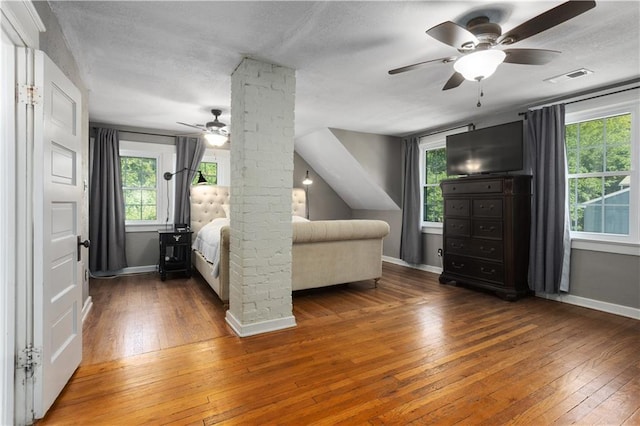 6000 Cherry St, Kansas City, MO 64110 - bedroom featuring hardwood / wood-style flooring, a textured ceiling, ceiling fan, and decorative columns