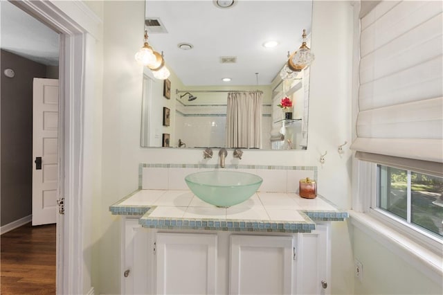 6000 Cherry St, Kansas City, MO 64110 - full bath with vanity, wood finished floors, backsplash, a shower with curtain, and recessed lighting
