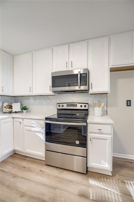 10201 Hillcrest Rd, Kansas City, MO 64134 - kitchen with appliances with stainless steel finishes, light countertops, and white cabinetry