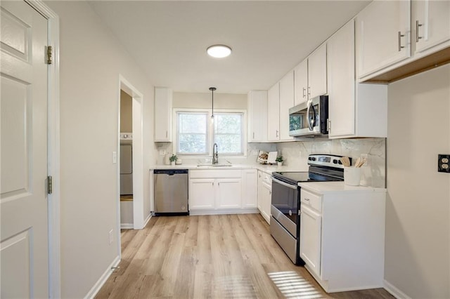 10201 Hillcrest Rd, Kansas City, MO 64134 - kitchen featuring stainless steel appliances, light wood-type flooring, tasteful backsplash, white cabinets, and light countertops