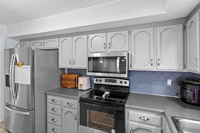 820 S Virginia Ln, Olathe, KS 66061 - kitchen featuring appliances with stainless steel finishes, a textured ceiling, tasteful backsplash, and white cabinets