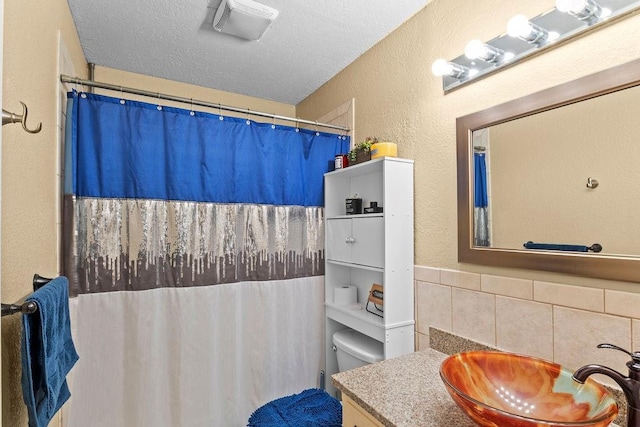 820 S Virginia Ln, Olathe, KS 66061 - full bath featuring vanity, a textured wall, a shower with shower curtain, and tasteful backsplash