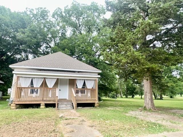 522 S 11th St, Independence, KS 67301 - view of front of property featuring roof with shingles, a front lawn, view of scattered trees, and a porch