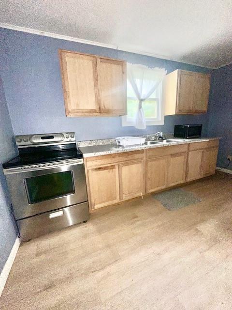 522 S 11th St, Independence, KS 67301 - kitchen with stainless steel electric range oven, light countertops, light brown cabinetry, and a textured ceiling
