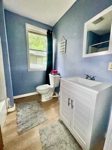 522 S 11th St, Independence, KS 67301 - bathroom with a shower, wood finished floors, vanity, and a tub to relax in