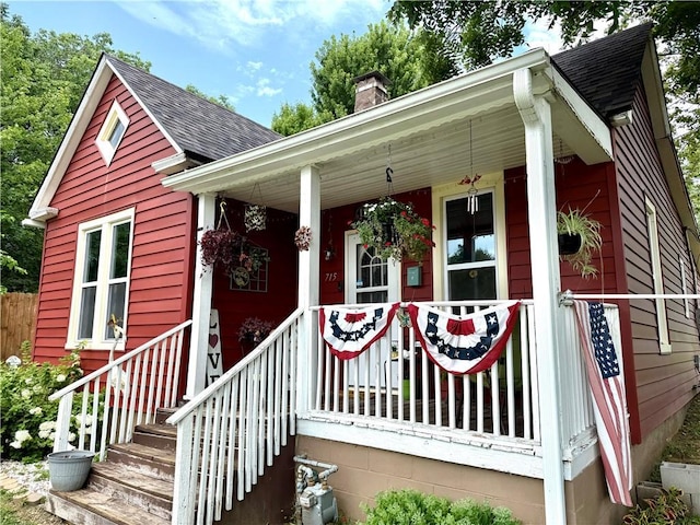 715 Harmon St, Saint Joseph, MO 64504 - view of front of house with roof with shingles, a chimney, and covered porch