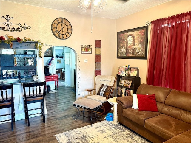 715 Harmon St, Saint Joseph, MO 64504 - living area with arched walkways, dark wood-style flooring, a textured ceiling, and a ceiling fan