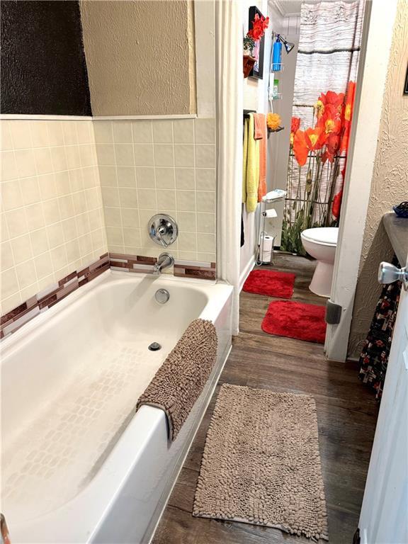 715 Harmon St, Saint Joseph, MO 64504 - bathroom featuring a garden tub, wood finished floors, and a textured wall