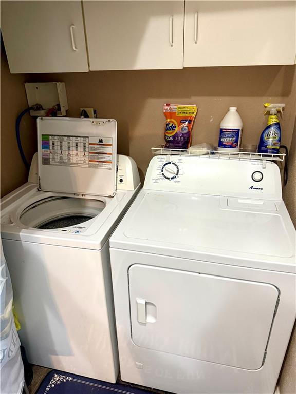 715 Harmon St, Saint Joseph, MO 64504 - laundry area featuring independent washer and dryer and cabinet space