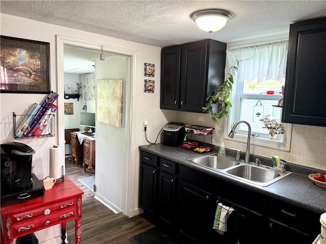 715 Harmon St, Saint Joseph, MO 64504 - kitchen with dark cabinets, dark wood finished floors, a textured ceiling, dark countertops, and tasteful backsplash