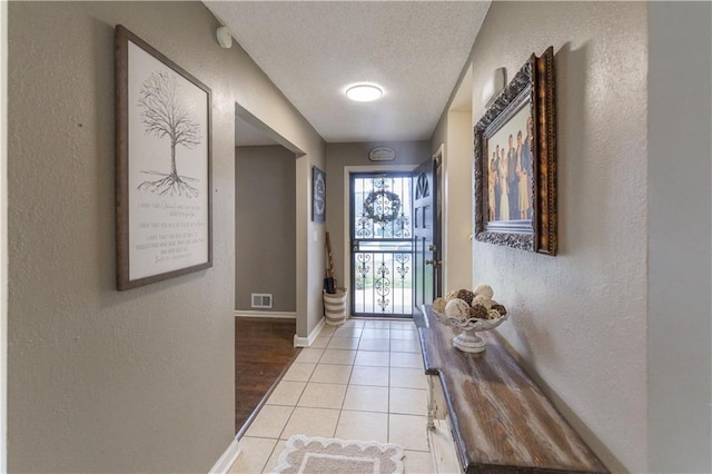 12408 Monroe Ave, Grandview, MO 64030 - entryway featuring a textured wall, a textured ceiling, and light tile patterned flooring