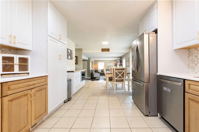 12408 Monroe Ave, Grandview, MO 64030 - kitchen with appliances with stainless steel finishes, light countertops, open floor plan, light tile patterned floors, and backsplash