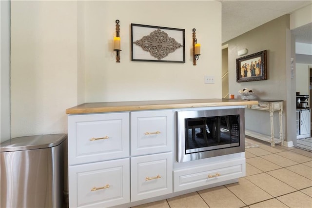 12408 Monroe Ave, Grandview, MO 64030 - kitchen view of stainless steel microwave, white cabinetry, and light countertops
