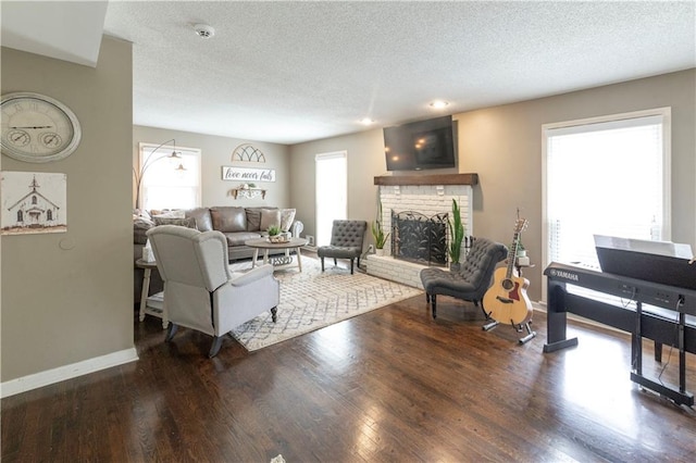 12408 Monroe Ave, Grandview, MO 64030 - living area with a brick fireplace, a textured ceiling, and wood finished floors