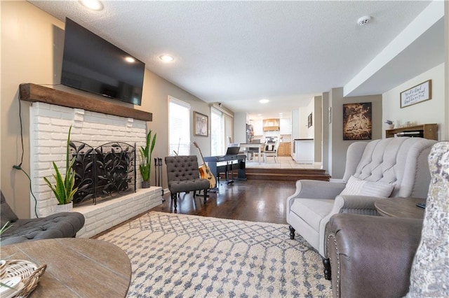 12408 Monroe Ave, Grandview, MO 64030 - living room with dark wood-style floors, a textured ceiling, a fireplace, and recessed lighting