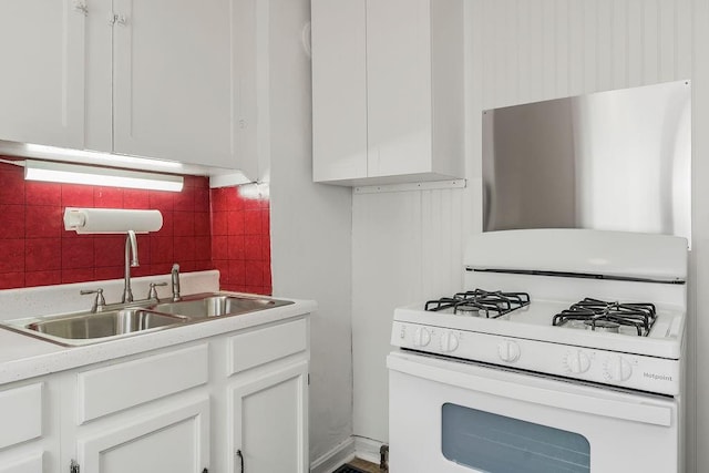 2527 N 18th St, Kansas City, KS 66104 - kitchen featuring white gas range oven, white cabinets, tasteful backsplash, and light countertops