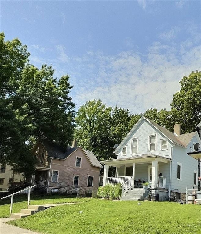 2006 Agnes Ave, Kansas City, MO 64127 - rear view of property with a porch and a yard