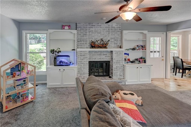 5300 NW 58th Ter, Kansas City, MO 64151 - living room with a textured ceiling, ceiling fan, carpet flooring, and a brick fireplace