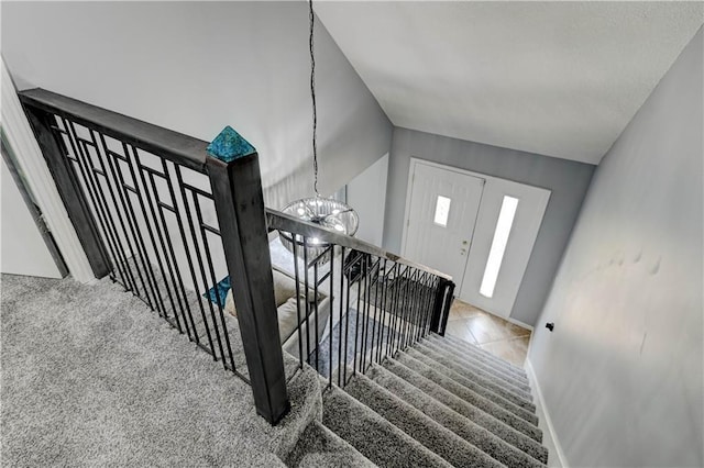 5300 NW 58th Ter, Kansas City, MO 64151 - stairway featuring a chandelier and tile patterned flooring